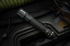 SPERAS EST30 2600lm 518m tactical flashlight resting on a hard case featuring a robust 4-mode mechanical rotary ring for zero fumble operation