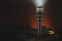 SPERAS PZ21 tactical hunting flashlight standing on outdoor gear with green battery indicator light