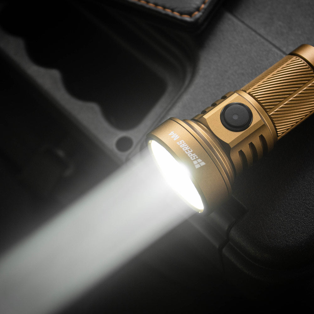 Desert tan SPERAS M4 flashlight turned on, demonstrating its powerful 2000-lumen focused beam and extreme 700-meter throw