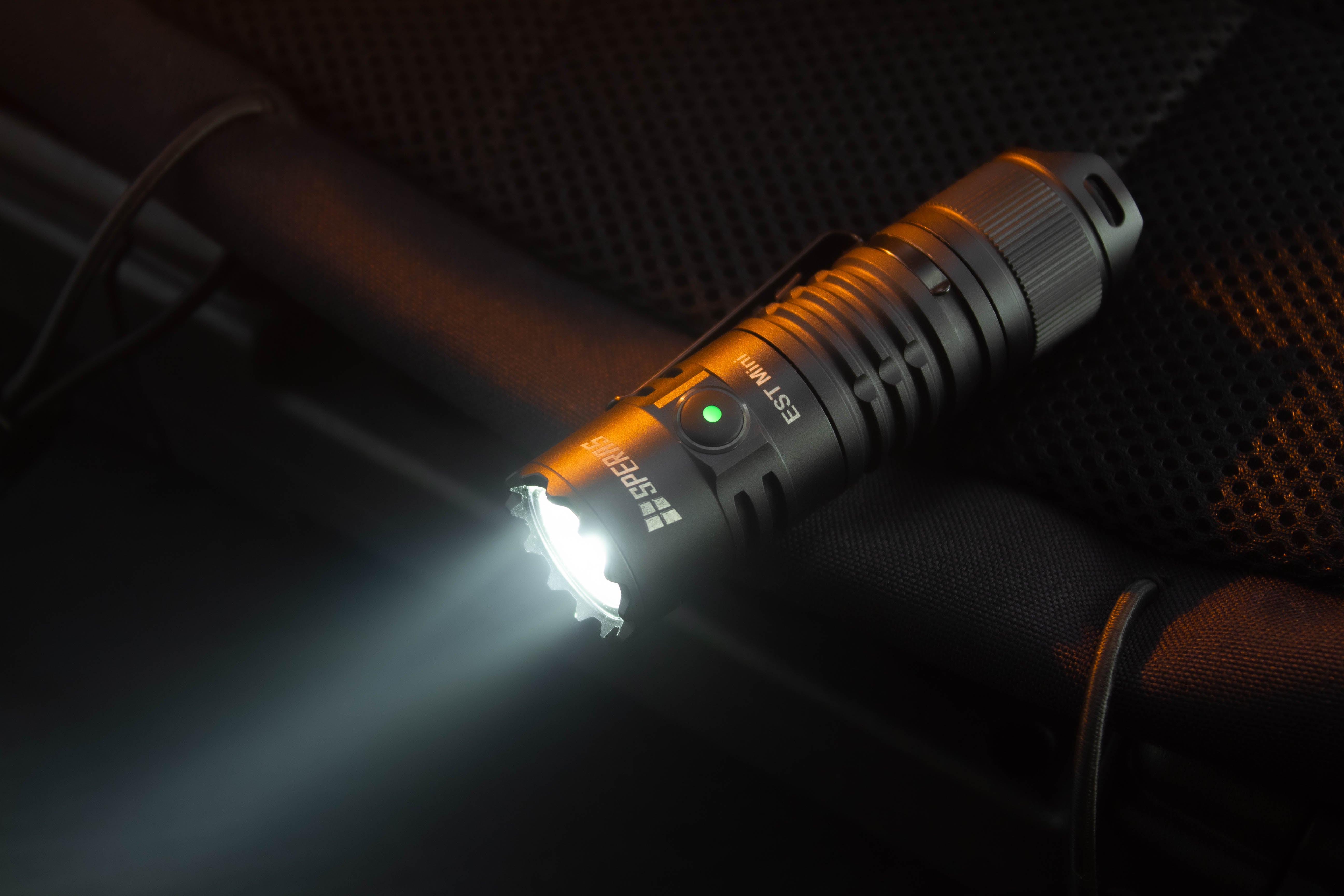 SPERAS EST Mini tactical EDC flashlight blasting a 1900 lumen max output beam with a green battery indicator on the side switch